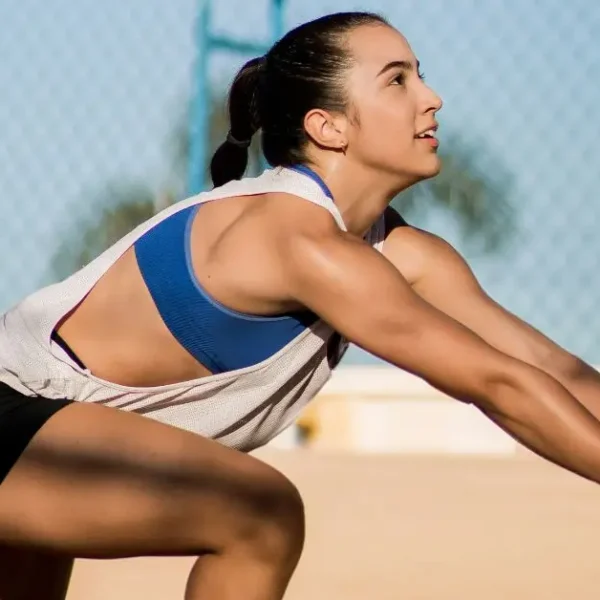 How to Hold Your Hands in Volleyball: Female beach volleyball player in action, focused and performing a dig during a game
