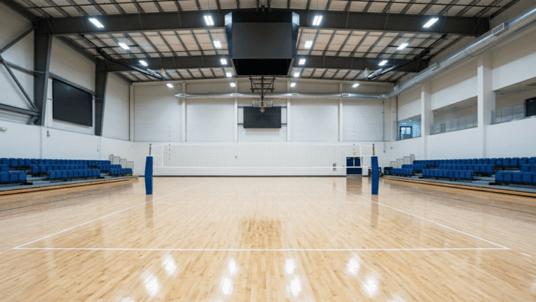 Wide-angle view of a pristine empty professional indoor volleyball court.