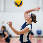 Volleyball Hairstyles for Short Hair: Game-Day Looks in 2026 4 A young female volleyball player with short bob haircut styled into a neat low bun secured with a sports headband on an indoor volleyball court during practice.